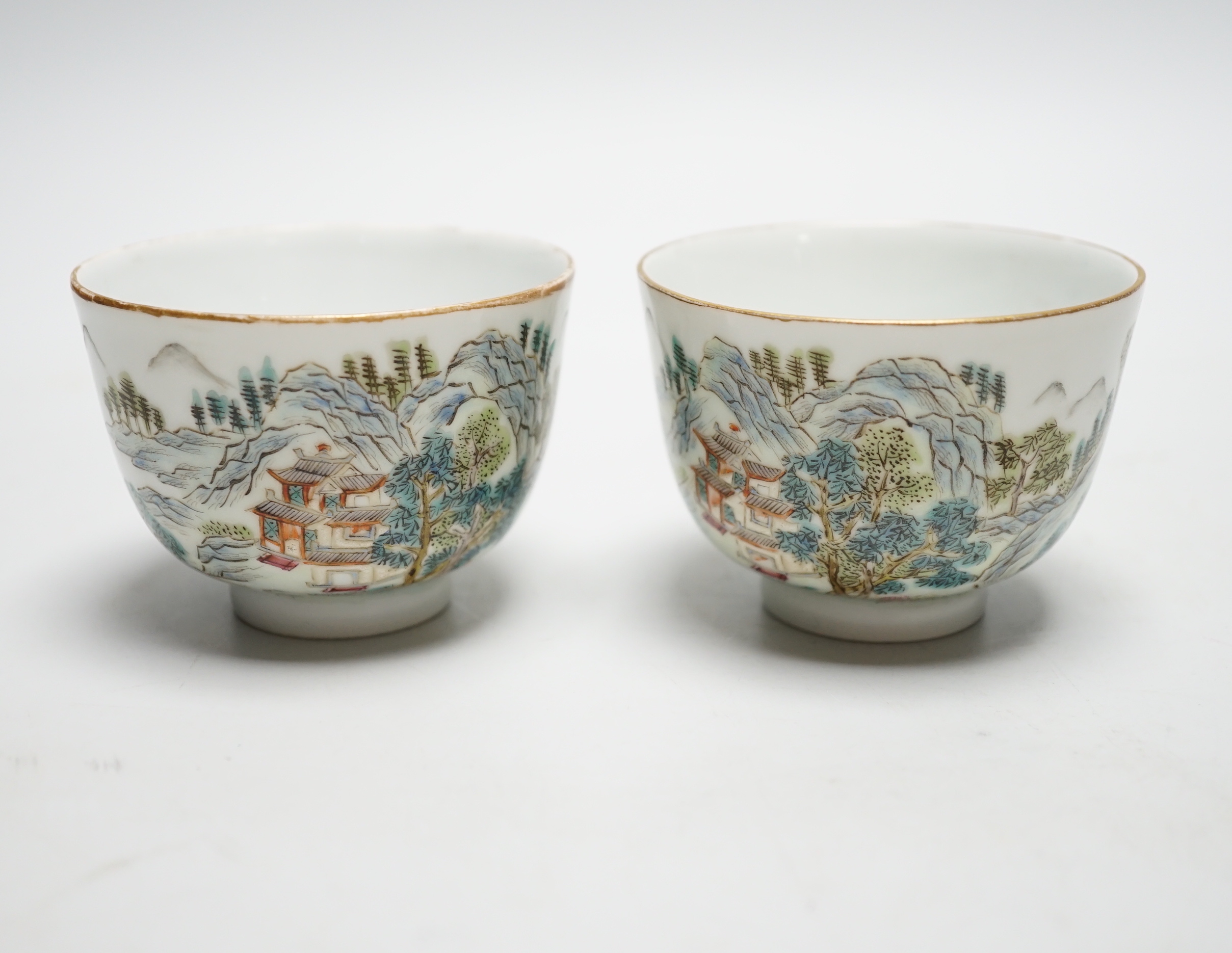 A pair of Chinese enamelled porcelain cups, landscapes and pagodas, 6cm tall